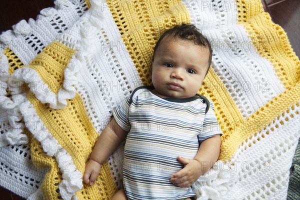 Mixed race baby laying on blanket