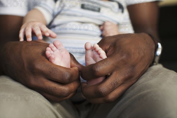 Father holding baby's small feet