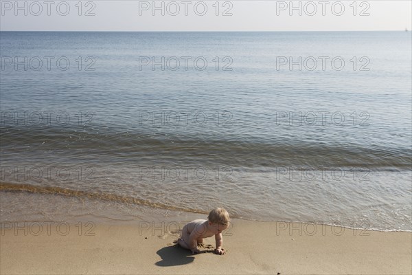 Caucasian baby playing on beach