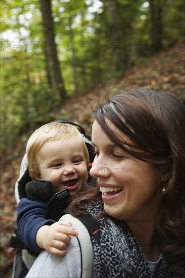 Caucasian mother carrying toddler on back