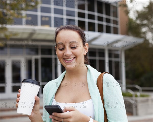 Caucasian student using cell phone on campus