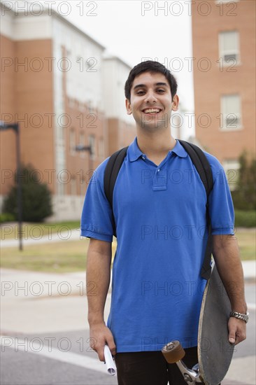 Middle Eastern student carrying skateboard