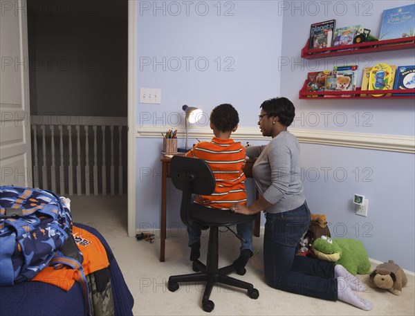 Mother helping son with homework