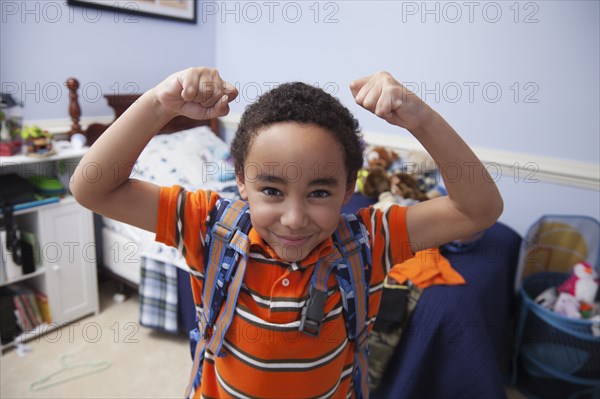 Mixed race boy wearing backpack in bedroom