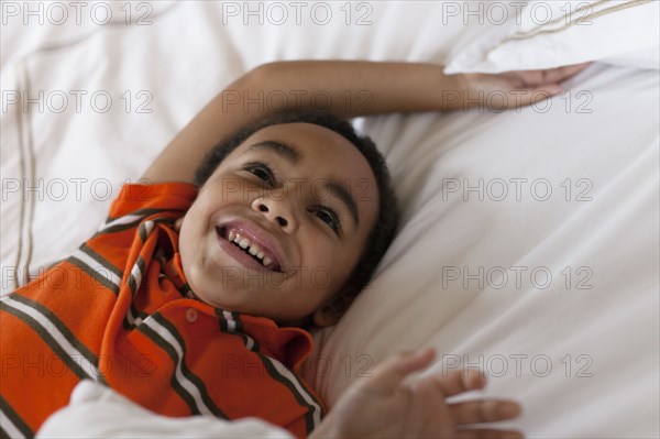Mixed race boy laying in bed