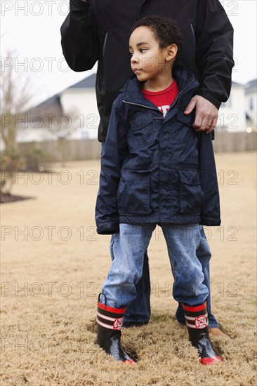 Father and son standing in field