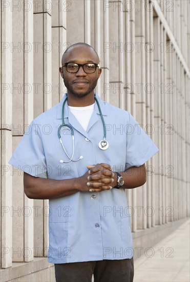 Black doctor standing on city street