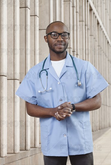 Black doctor standing on city street