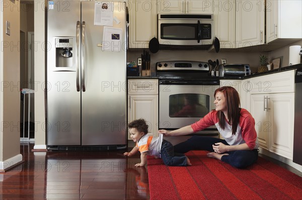 Mother and baby playing in kitchen