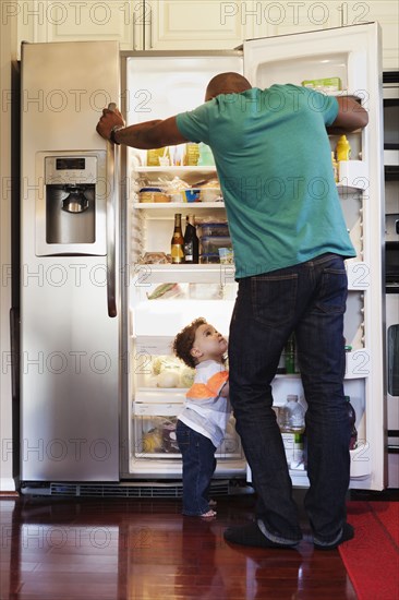 Father and baby looking through fridge
