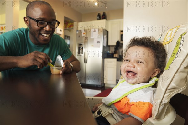 Father feeding baby at table