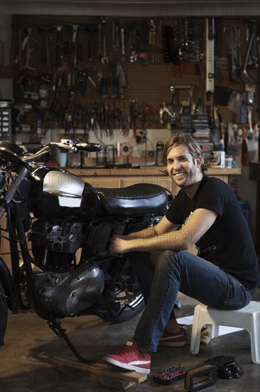 Caucasian mechanic working on motorcycle