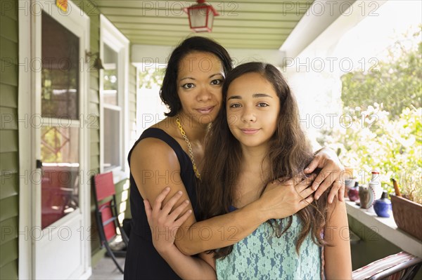 Mixed race mother and daughter hugging