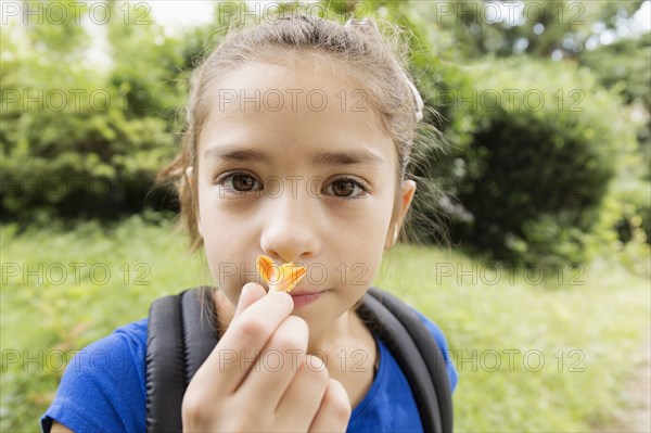 Mixed race girl smelling flower