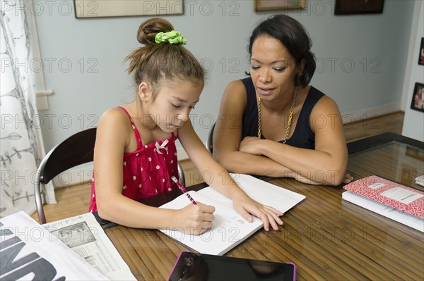 Mixed race mother helping daughter with homework