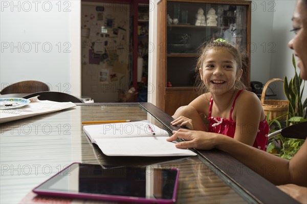 Mixed race mother helping daughter do homework