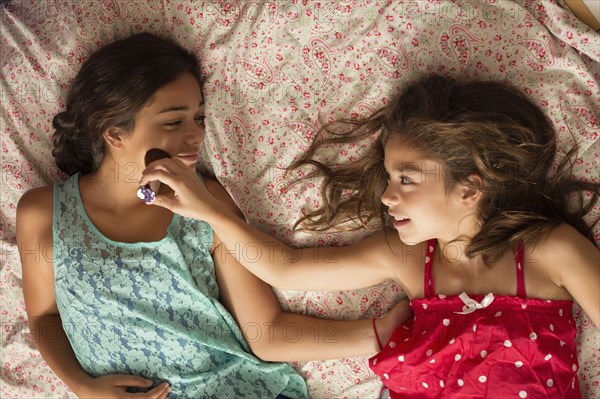 Mixed race sisters relaxing on bed