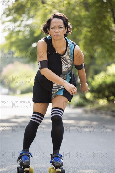 Mixed race woman roller skating outdoors