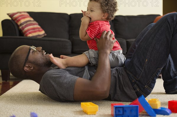 Father and toddler son playing in living room