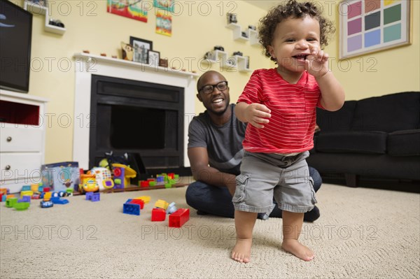 Father and toddler son playing in living room