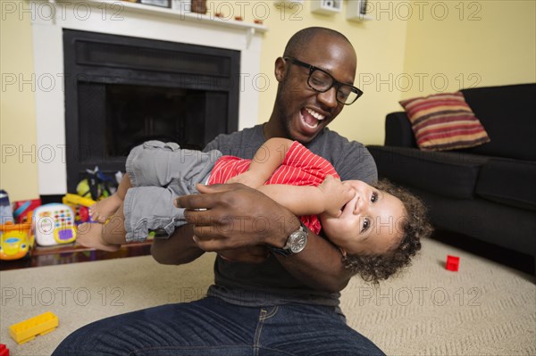 Father and toddler son playing in living room