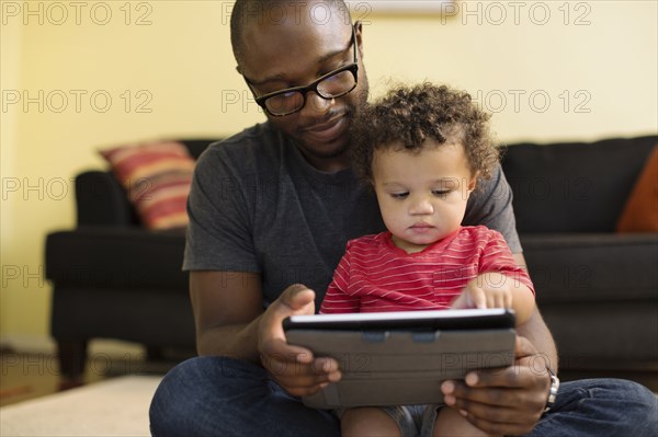 Father and toddler using digital tablet