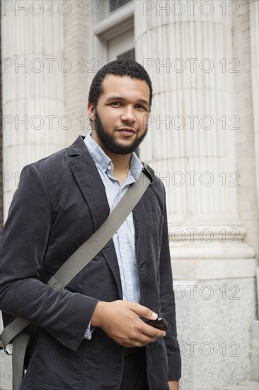 Mixed race businessman holding cell phone