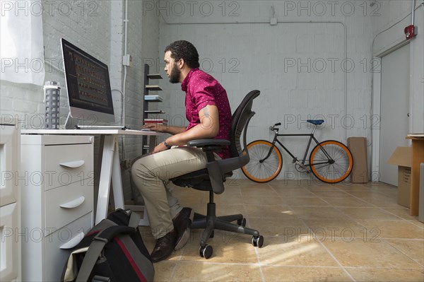 Mixed race businessman working at desk