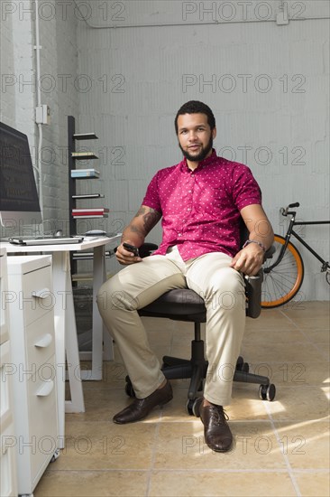 Mixed race businessman sitting at desk