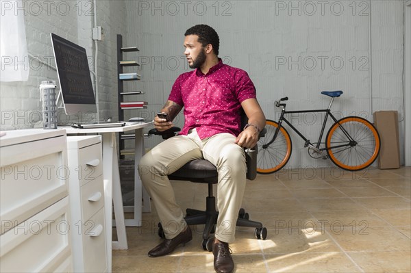 Mixed race businessman sitting at desk