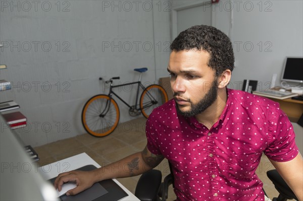 Mixed race businessman sitting at desk