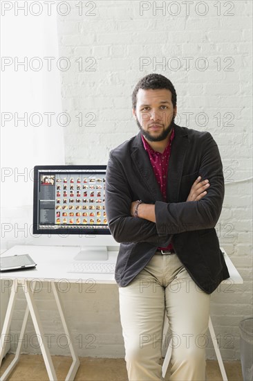 Mixed race businessman sitting on desk