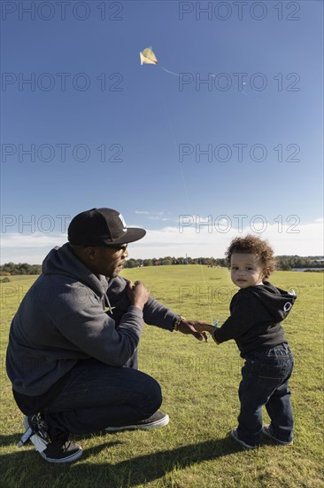 Father and son flying kite in park