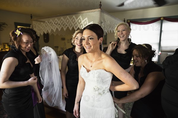 Bridesmaids helping bride get ready