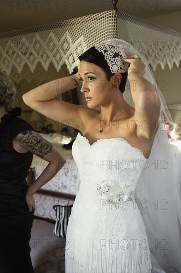 Caucasian bride adjusting her veil