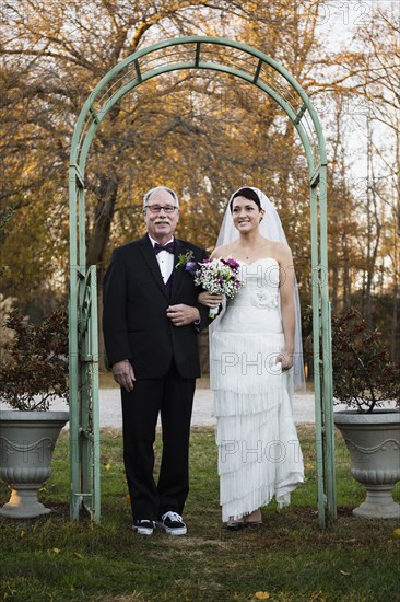 Caucasian father walking bride down aisle