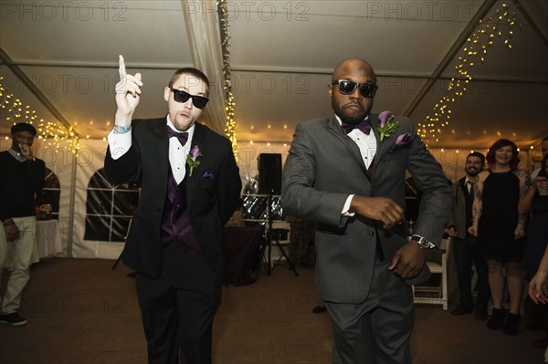 Groom and groomsman dancing at reception