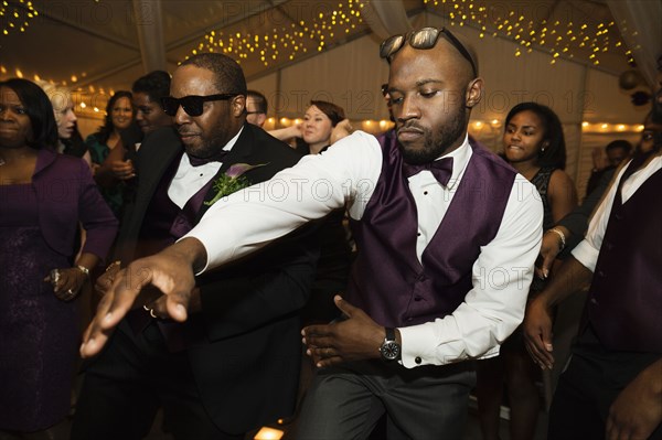 Groom and groomsman dancing at reception