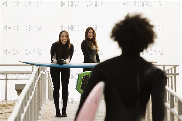 Surfers carrying boards to beach