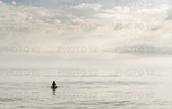Hispanic surfer floating in water