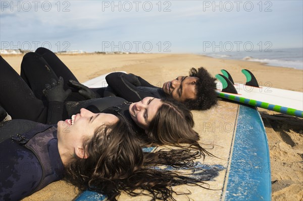 Surfers laying on boards on beach