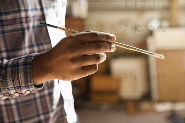 Mixed race artist painting in studio