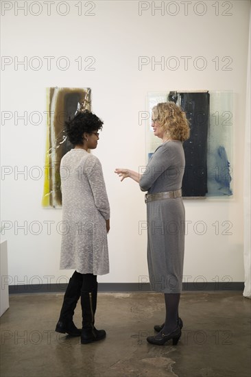 Gallery owner talking to patron