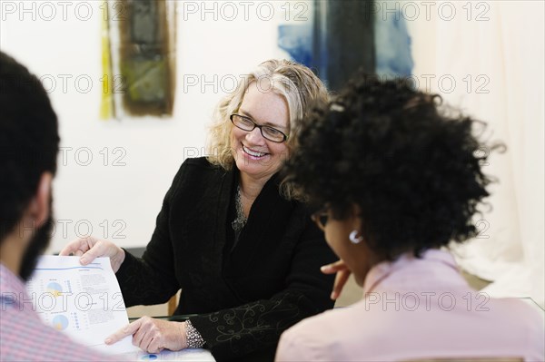 Businesswoman talking to young couple