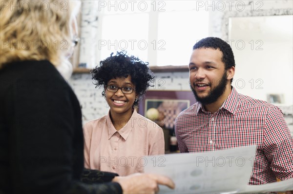 Businesswoman talking to young couple