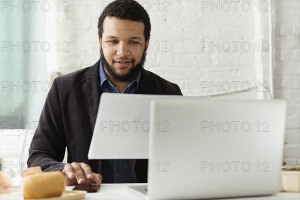 Mixed race businessman working at desk