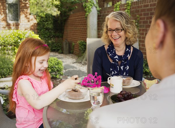 Caucasian family eating together in backyard