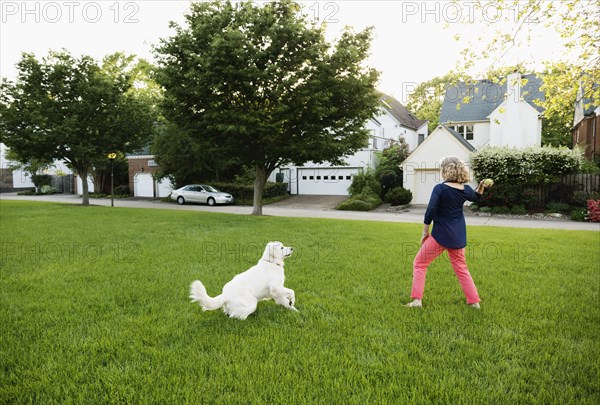 Caucasian woman playing with dog in park