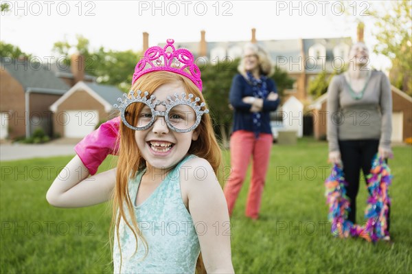 Caucasian girl playing dress up in park