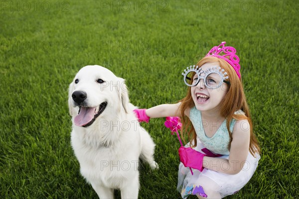 Caucasian girl playing dress up in park